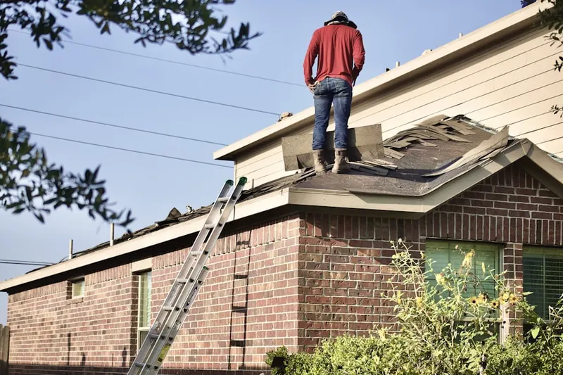 Professional roofer working on a residential roof in Avenel